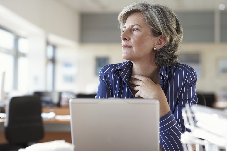 Mature businesswoman by laptop in office
